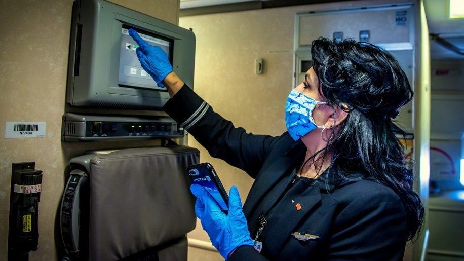 Une hôtesse avec un masque de la compagnie aérienne United